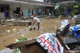 Sejumlah relawan membersihkan material lumpur pascabanjir bandang di Ponpes Ar-Rosyid, Bangsalsari, Jember, Jawa Timur, Rabu (13/1/2021). Akibat banjir bandang yang terjadi pada Selasa (12/1) malam tersebut menyebabkan sejumlah rumah terendam lumpur. Antara Jatim/Seno/ZK