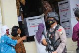 Personel Brimob berjaga saat proses bongkar muatan mobil pendingin yang mengangkut vaksin COVID-19 Sinovac di Gudang Farmasi Dinas Kesehatan Kota Surabaya, Surabaya, Jawa Timur, Rabu (13/1/2021). Dinas Kesehatan Provinsi Jawa Timur mulai mendistribusikan vaksin COVID-19 Sinovac ke Surabaya sebanyak 15.000 dosis, Kabupaten Sidoarjo sebanyak 4.000 dosis dan Kabupaten Gresik sebanyak 3.000 dosis. Antara Jatim/Didik/Zk