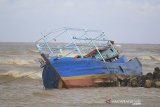 Sebuah kapal nelayan pencari cumi karam di sekitar muara Eretan wetan, Kandanghaur, Indramayu, Jawa Barat, Rabu (13/1/2021). Kapal Cumi tersebut karam akibat diterjang gelombang tinggi saat akan memasuki muara. ANTARA JABAR/Dedhez Anggara/agr