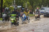 Sejumlah pengendara sepeda motor menorobos banjir yang menggenangi jalan Brigjend H Hasan Basry di Banjarmasin, Kalimantan Selatan, Kamis (14/1/2021). Tingginya intensitas curah hujan mengakibatkan sejumlah kawasan di Kota Banjarmasin terendam banjir. Foto Antaranews Kalsel/Bayu Pratama S.