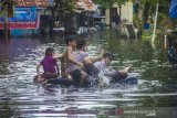 Warga beraktivitas di permukiman padat penduduk yang terendam banjir di Banjarmasin, Kalimantan Selatan, Kamis (14/1/2021). Tingginya intensitas curah hujan mengakibatkan sejumlah kawasan di Kota Banjarmasin terendam banjir. Foto Antaranews Kalsel/Bayu Pratama S.