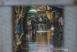 Warga beraktivitas di permukiman padat penduduk yang terendam banjir di Banjarmasin, Kalimantan Selatan, Kamis (14/1/2021). Tingginya intensitas curah hujan mengakibatkan sejumlah kawasan di Kota Banjarmasin terendam banjir. Foto Antaranews Kalsel/Bayu Pratama S.