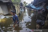 Warga beraktivitas di permukiman padat penduduk yang terendam banjir di Banjarmasin, Kalimantan Selatan, Kamis (14/1/2021). Tingginya intensitas curah hujan mengakibatkan sejumlah kawasan di Kota Banjarmasin terendam banjir. Foto Antaranews Kalsel/Bayu Pratama S.