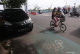 Pengendara sepeda melintas pada jalur tengah karena jalur khusus sepeda digunakan untuk parkir mobil di Kota Kediri, Jawa Timur, Jumat (15/1/2021). Jalur khusus sepeda di sejumlah ruas jalan di wilayah tersebut kurang berfungsi maksimal karena banyak digunakan untuk parkir mobil. Antara Jatim/Prasetia Fauzani/ZK