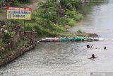 Sejumlah anak bermain air di sungai Desa Tugurejo, Kediri, Jawa Timur, Kamis (14/1/2021). Sungai menjadi tempat pilihan bermain anak-anak seiring masih ditutupnya sejumlah ruang terbuka hijau dan wahanan permainan saat pandemi COVID-19. Antara Jatim/Prasetia Fauzani/ZK