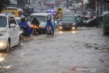 Kendaraan melintasi genangan air di Cinunuk, Kabupaten Bandung, Jawa Barat, Sabtu (16/1/2021). Hujan lebat di Bandung raya sejak Sabtu (16/1) siang hingga sore hari membuat Jalan Nasional dari Bandung menuju Garut dan Sumedang tergenang air serta membuat permukiman warga di Bumi Orange terendam Banjir setinggi 50 sentimeter hingga satu meter. ANTARA JABAR/Raisan Al Farisi/agr