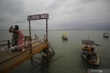 Pengunjung berswafoto saat berlibur di kawasan wisata Dermaga Rindu di Bangkalan, Jawa Timur, Sabtu (16/1/2021). Tempat wisata berkonsep resto dan kafe dengan pemandangan Jembatan Suramadu tersebut menjadi salah satu destinasi wisata yang dikunjungi banyak wisatawan saat berlibur ke Pulau Madura. Antara Jatim/Moch Asim/ZK