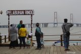 Pengunjung menikmati suasana saat berlibur di kawasan wisata Dermaga Rindu di Bangkalan, Jawa Timur, Sabtu (16/1/2021). Tempat wisata berkonsep resto dan kafe dengan pemandangan Jembatan Suramadu tersebut menjadi salah satu destinasi wisata yang dikunjungi banyak wisatawan saat berlibur ke Pulau Madura. Antara Jatim/Moch Asim/ZK