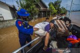 Tim Sar Ditpolairud Polda Kalsel mengevakuasi warga yang terdampak banjir di Desa Dalam Pagar Ulu, Kabupaten Banjar, Kalimantan Selatan, Minggu (17/1/2021). Pusat Data Informasi dan Komunikasi Kebencanaan Badan Nasional Penanggulangan Bencana melaporkan sebanyak 10 Kabupaten/Kota terdampak banjir di Provinsi Kalimantan Selatan, antara lain Kabupaten Tapin, Kabupaten Banjar, Kota Banjar Baru, Kota Tanah Laut, Kota Banjarmasin, Kabupaten Hulu Sungai Tengah, Kabupaten Balangan, Kabupaten Tabalong, Kabupataen Hulu Sungai Selatan, dan Kabupaten Batola. Foto Antaranews Kalsel/Bayu Pratama S.