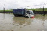 Sebuah truk terjebak banjir di jalan raya Porong, Sidoarjo, Jawa Timur, Senin (18/1/2021). Curah hujan yang tinggi sejak Minggu (17/1) malam mengakibatkan banjir yang merendam Jalan Raya Porong sehingga mengganggu kelancaran transportasi umum. Antara Jatim/Umarul Faruq/zk.