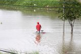 Warga menerobos banjir yang merendam jalan raya Porong, Sidoarjo, Jawa Timur, Senin (18/1/2021). Curah hujan yang tinggi sejak Minggu (17/1) malam mengakibatkan banjir yang merendam Jalan Raya Porong sehingga mengganggu kelancaran transportasi umum. Antara Jatim/Umarul Faruq/zk.