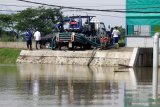 Petugas memasang pipa pada mobil pompa (Mobile Flood Pump) untuk mengatasi banjir di jalan raya Porong, Sidoarjo, Jawa Timur, Senin (18/1/2021). Pusat Pengendalian Lumpur Sidoarjo (PPLS) melakukan penyedotan genangan air dengan mesin pompa dan Mobile Flood Pump untuk mengurangi debit air yang menggenangi jalan Raya Porong. Antara Jatim/Umarul Faruq/zk.