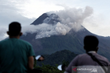 Warga mengamati Gunung Merapi yang mengeluarkan awan panas di Wonorejo, Hargobinangun, Pakem, Sleman, D.I Yogyakarta, Senin (18/1/2021). BPPTKG D.I Yogyakarta mencatat pada periode pengamatan Senin (18/1) pukul 00:00-06:00 WIB secara visual, Gunung Merapi mengeluarkan awan panas sebanyak satu kali dengan jarak luncur 1.000 meter, tinggi kolom 50 meter ke Tenggara arah Barat Daya serta guguran lava pijar sebanyak enam kali dengan jarak luncur maksimum 600 meter ke Barat Daya. ANTARA FOTO/Andreas Fitri Atmoko/hp. 