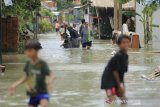 Warga menerobos banjir yang merendam desa Suranenggala Lor, Kecamatan Suranenggala, Kabupaten Cirebon, Jawa Barat, Selasa (19/1/2021). Banjir akibat luapan sungai dan tingginya intensitas hujan di kawasan itu membuat ratusan rumah warga terendam banjir setinggi 50 sentimeter hingga satu meter. ANTARA JABAR/Dedhez Anggara/agr