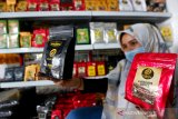 Pekerja memperlihatkan bubuk kopi arabika gayo yang telah dikemas dengan bungkusan hasil kerajinan Usaha Mikro, Kecil dan Menengah (UMKM) rumah tangga dan Industri Kecil Menengah (IKM) di bazar UMK-IKM dan pasar murah Asia Mart Center, Banda Aceh, Aceh, Selasa (19/1/2021). Pemasaran secara mandiri, media sosial dan keterlibatan pihak swasta dengan menggelar bazar atau pasar murah diharapkan dapat membangkitkan kembali perekonomian ditengah pandemi COVID-19. Antara Aceh/Irwansyah Putra.