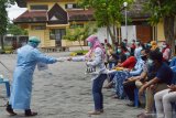Petugas kesehatan membagikan alat swab saat tes usap (swab) massal di halaman Wisma Haji Kota Madiun, Jawa Timur, Selasa (19/1/2021). Pemkot Madiun memfasilitasi swab secara gratis bagi warga yang memiliki riwayat kontak erat dengan pasien positif COVID-19 guna pencegahan penyebaran virus corona seiring dengan terus meningkatnya jumlah kasus positif COVID-19 hingga daerah tersebut berstatus zona merah COVID-19. Antara Jatim/Siswowidodo/ZK