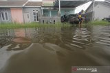 Warga menerobos genangan banjir di perumahan desa Sindang, Kecamatan Sindang, Indramayu, Jawa Barat, Kamis (21/1/2021). Buruknya drainase membuat sejumlah rumah warga di daerah itu kerap digenangi banjir ketika hujan turun. ANTARA JABAR/Dedhez Anggara/agr