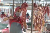 Penjual memotong daging sapi dagangannya di Pasar Setonobetek, Kota Kediri, Jawa Timur, Rabu (20/1/2021). Harga daging sapi di daerah tersebut stabil pada kisaran harga Rp100 ribu per kilogram dan tidak terpengaruh oleh tingginya harga daging sapi impor karena pedagang mengandalkan pasokan daging dari peternak sapi lokal. Antara Jatim/Prasetia Fauzani/ZK