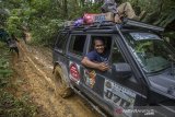 Kanit Narkoba Polres Hulu Sungai Tengah John Robert menggunakan mobil jip dari Indonesia Offroad Federation (IOF) mengantarkan logistik bantuan korban bencana banjir bandang menuju ke Desa Arangani di Kecamatan Hantakan, Kabupaten Hulu Sungai Tengah, Kalimantan Selatan, Jumat (22/1/2021). Polres Hulu Sungai Tengah bersama relawan dan Anggota DPRD Kabupaten Hulu Sungai Tengah Fraksi PPP Muhammad Jaini mendistribusikan logitsik bantuan bencana banjir bandang di pedalaman meratus yang sulit di jangkau karena akses utama tertutup longsor. Foto Antaranews Kalsel/Bayu Pratama S.