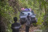 Kanit Narkoba Polres Hulu Sungai Tengah John Robert menggunakan mobil jip dari Indonesia Offroad Federation (IOF) mengantarkan logistik bantuan korban bencana banjir bandang menuju ke Desa Arangani di Kecamatan Hantakan, Kabupaten Hulu Sungai Tengah, Kalimantan Selatan, Jumat (22/1/2021). Polres Hulu Sungai Tengah bersama relawan dan Anggota DPRD Kabupaten Hulu Sungai Tengah Fraksi PPP Muhammad Jaini mendistribusikan logitsik bantuan bencana banjir bandang di pedalaman meratus yang sulit di jangkau karena akses utama tertutup longsor. Foto Antaranews Kalsel/Bayu Pratama S.