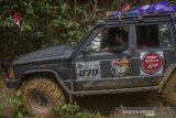 Kanit Narkoba Polres Hulu Sungai Tengah John Robert menggunakan mobil jip dari Indonesia Offroad Federation (IOF) mengantarkan logistik bantuan korban bencana banjir bandang menuju ke Desa Arangani di Kecamatan Hantakan, Kabupaten Hulu Sungai Tengah, Kalimantan Selatan, Jumat (22/1/2021). Polres Hulu Sungai Tengah bersama relawan dan Anggota DPRD Kabupaten Hulu Sungai Tengah Fraksi PPP Muhammad Jaini mendistribusikan logitsik bantuan bencana banjir bandang di pedalaman meratus yang sulit di jangkau karena akses utama tertutup longsor. Foto Antaranews Kalsel/Bayu Pratama S.