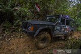 Kanit Narkoba Polres Hulu Sungai Tengah John Robert menggunakan mobil jip dari Indonesia Offroad Federation (IOF) mengantarkan logistik bantuan korban bencana banjir bandang menuju ke Desa Arangani di Kecamatan Hantakan, Kabupaten Hulu Sungai Tengah, Kalimantan Selatan, Jumat (22/1/2021). Polres Hulu Sungai Tengah bersama relawan dan Anggota DPRD Kabupaten Hulu Sungai Tengah Fraksi PPP Muhammad Jaini mendistribusikan logitsik bantuan bencana banjir bandang di pedalaman meratus yang sulit di jangkau karena akses utama tertutup longsor. Foto Antaranews Kalsel/Bayu Pratama S.