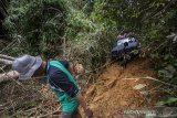 Kanit Narkoba Polres Hulu Sungai Tengah John Robert menggunakan mobil jip dari Indonesia Offroad Federation (IOF) mengantarkan logistik bantuan korban bencana banjir bandang menuju ke Desa Arangani di Kecamatan Hantakan, Kabupaten Hulu Sungai Tengah, Kalimantan Selatan, Jumat (22/1/2021). Polres Hulu Sungai Tengah bersama relawan dan Anggota DPRD Kabupaten Hulu Sungai Tengah Fraksi PPP Muhammad Jaini mendistribusikan logitsik bantuan bencana banjir bandang di pedalaman meratus yang sulit di jangkau karena akses utama tertutup longsor. Foto Antaranews Kalsel/Bayu Pratama S.