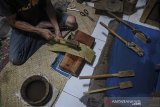 Seniman Ahmad Mufid Sururi (46) menempa kulit kayu pohon paper mulberry (Broussonetia Papyryfera Vent) untuk dijadikan daluang di Ujung Berung, Bandung, Jawa Barat, Jumat (22/1/2021). Ahmad Mufid Sururi berinisiatif untuk melestarikan daluang atau kertas tradisional Indonesia yang digunakan untuk menulis naskah dan menyungging wayang beber serta sebagai salah satu langkah mengenalkan tradisi pembuatan daluang kepada generasi berikutnya. ANTARA JABAR/Raisan Al Farisi/agr