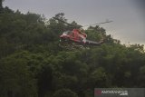 Helikopter Badan Nasional Penanggalungan Bencana (BNPB) jenis Bell 412 EP membawa logistik bantuan korban banjir bandang melintas di lereng pegunungan meratus di Desa Datar Ajab, Kabupaten Hulu Sungai Tengah, Kalimantan Selatan, Minggu (24/1/2021). Bantuan berupa tenda, sembako serta perlatan dapur dari TNI Angakatan Udara Lanud Sjamsudin Noor, Dharma Pertiwi Peduli, Kepala Staf Angkatan Udara dan Badan Penanggulangan Bencana Daerah (BPBD) Porvinsi Kalsel didistribusikan melalui jalur udara ke wilayah pedalaman pegunungan meratus. Foto Antaranews Kalsel/ Bayu Pratama S.