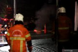 Petugas Dinas Pemadam Kebakaran Kota Surabaya berjaga di lokasi saluran air yang mengeluarkan api di dekat Stasiun Pengisian Bahan Bakar Umum (SPBU) Jalan Margomulyo Surabaya, Jawa Timur, Minggu (24/1/2021) malam. Sekitar 12 kendaraan pemadam kebakaran dikerahkan untuk  memadamkan api tersebut.  Antara Jatim/Didik/Zk