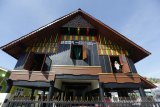 Warga melihat dari jendela rumah adat Aceh yang dibangun melalui program Kota Tanpa Kumuh (Kotaku) Kementerian Pekerjaan Umum dan Perumahan Rakyat di Desa Lambhuk, Banda Aceh, Aceh, Selasa (26/1/2021). Program Kotaku merupakan upaya pemerintah untuk mempercepat penanganan permukiman kumuh, mendukung gerakan 100 persen akses universal air minum, 0 persen permukiman kumuh dan 100 persen akses sanitasi layak (100-0-100). Antara Aceh/Irwansyah Putra.