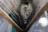 Pekerja membawa kayu untuk merehab kapal nelayan di galangan tradisional Gampong Mulia, Banda Aceh, Aceh, Selasa (26/1/2021). Pelaku usaha galangan kapal tradisional mengaku kesulitan memperoleh bahan baku kayu dan berharap adanya kebijakan dari Pemerintah guna memenuhi kebutuhan bahan baku utama untuk perbaikan kapal kayu. Antara Aceh/Irwansyah Putra.