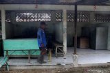 Seorang warga melintas di kios makanan di pasar hewan yang ditutup di Ngawi, Jawa Timur, Rabu (27/1/2021). Pemerintah setempat menutup sepuluh pasar hewan di kawasan tersebut guna mencegah makin meluasnya penyebaran COVID-19. Antara Jatim/Ari Bowo Sucipto/zk.