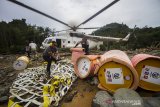 Petugas menurunkan logistik bantuan bahan bakar minyak (BBM) di Desa Datar Ajab, Kabupaten Hulu Sungai Tengah, Kalimantan Selatan, Jumat (29/1/2021).TNI Angkatan Udara Lanud Sjamsudin Noor menggunakan helikopter milik Badan Nasional Penanggulangan Bencana (BNPB) mendistribusikan BBM jenis pertamax dan minyak tanah bantuan dari PT Pertamina (Persero) ke lokasi pengungsian di wilayah pedalaman Pegunungan Meratus untuk digunakan sebagai operasional para relawan serta kebutuhan dapur umum. Foto Antaranews Kalsel/Bayu Pratama S.