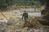 Letda CKM dr Fitriandrirama dari Pusat Kesehatan Angkatan Darat (Puskesad) TNI Angakatan Darat melintasi puing-puing batang pohon yang hanyut akibat banjir bandang di Desa Datar Ajab, Kabupaten Hulu Sungai Tengah, Kalimantan Selatan, Jumat (29/1/2021). Puskesad TNI Angkatan Darat telah memeriksa 400 warga yang menjadi korban banjir hingga menjangkau pedalaman meratus di Kabupaten Hulu Sungai Tengah dalam operasi bantuan penanganan banjir di Kalimantan Selatan. Foto Antaranews Kalsel/Bayu Pratama S.