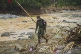 Letda CKM dr Fitriandrirama dari Pusat Kesehatan Angkatan Darat (Puskesad) TNI Angakatan Darat melintasi puing-puing batang pohon yang hanyut akibat banjir bandang di Desa Datar Ajab, Kabupaten Hulu Sungai Tengah, Kalimantan Selatan, Jumat (29/1/2021). Puskesad TNI Angkatan Darat telah memeriksa 400 warga yang menjadi korban banjir hingga menjangkau pedalaman meratus di Kabupaten Hulu Sungai Tengah dalam operasi bantuan penanganan banjir di Kalimantan Selatan. Foto Antaranews Kalsel/Bayu Pratama S.