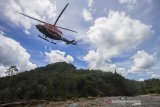 Helikopter Badan Nasional Penanggulangan Bencana (BNPB) jenis Bell 412 EP melintas di lereng Pegunungan Meratus usai menyalurkan paket sembako bantuan presiden bagi warga yang terdampak banjir bandang di pedalaman Pegunungan Meratus, Desa Datar Ajab, Kabupaten Hulu Sungai Tengah, Kalimantan Selatan, Selasa (2/2/2021).  Presiden Joko Widodo melalui Badan Nasional Penanggulangan Bencana (BNPB) menyalurkan 20 ribu paket sembako untuk memenuhi kebutuhan korban banjir di 11 Kabupaten/Kota Provinsi Kalimantan Selatan. Foto Antaranews Kalsel/Bayu Pratama S.