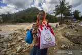 Seorang warga menunjukkan paket sembako bantuan presiden di Desa Datar Ajab, Kabupaten Hulu Sungai Tengah, Kalimantan Selatan, Selasa (2/2/2021). Presiden Joko Widodo melalui Badan Nasional Penanggulangan Bencana (BNPB) menyalurkan 20 ribu paket sembako untuk memenuhi kebutuhan korban banjir di 11 Kabupaten/Kota Provinsi Kalimantan Selatan. Foto Antaranews Kalsel/Bayu Pratama S.