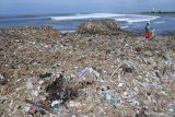 Warga mencari botol plastik dan kayu ditumpukan sampah di Pantai Pancer, Puger, Jember, Jawa Timur, Senin (1/2/2021). Banjir Daerah Aliran Sungai (DAS) Bedadung akhir pekan kemarin mengirimkan sampah ke Pantai Pancer Puger yang menjadi muara sungai tersebut. Antara Jatim/Seno/zk