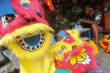 Perajin membuat kerajinan barongsai kecil di Surabaya, Jawa Timur, Kamis (4/2/2021). Kerajinan yang dibuat dari bahan kertas bekas itu dijual dengan harga Rp50 ribu sampai Rp350 ribu tergantung ukuran dan tingkat kesulitannya. Antara Jatim/Didik/Zk