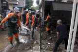 Relawan membantu membersihkan rumah warga yang terdampak banjir bandang di Desa Kepulungan, Gempol,  Pasuruan, Jawa Timur, Kamis (4/2/2021). Banjir bandang akibat Sungai Kambeng meluap tersebut mengakibatkan 11 rumah rusak parah, tiga rata dengan tanah dan puluhan rumah rusak ringan. Antara Jatim/Umarul Faruq/ZK