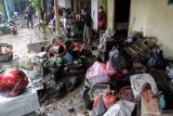 Warga membersihkan rumahnya yang terdampak banjir bandang di Desa Kepulungan, Gempol,  Pasuruan, Jawa Timur, Kamis (4/2/2021). Banjir bandang akibat Sungai Kambeng meluap tersebut mengakibatkan 11 rumah rusak parah, tiga rata dengan tanah dan puluhan rumah rusak ringan. Antara Jatim/Umarul Faruq/ZK