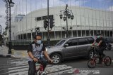 Pesepeda menggunakan masker saat menyeberangi Jalan Braga di Bandung, Jawa Barat, Kamis (4/2/2021). Kota Bandung menjadi salah satu daerah di Jawa Barat yang memiliki tingkat kepatuhan tinggi dalam penggunaan masker dengan persentase yang tak pernah kurang dari 90 persen. ANTARA FOTO/Raisan Al FarisiANTARA FOTO/RAISAN AL FARISI (ANTARA FOTO/RAISAN AL FARISI)