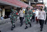 Kapolri Jenderal Pol Listyo Sigit Prabowo (kanan) bersama Panglima TNI Marsekal TNI Hadi Tjahjanto (ketiga kiri) dan Gubernur Bali Wayan Koster (kedua kanan) meninjau Pasar Kumbasari di Denpasar, Bali, Kamis (4/2/2021). Kunjungan tersebut dilakukan untuk meninjau penerapan protokol kesehatan (prokes) pencegahan COVID-19 di lingkungan pasar tradisional. ANTARA FOTO/Fikri Yusuf/nym.