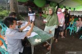 Warga terdampak pandemi COVID-19 mencairkan Bantuan Sosial Tunai (BST) tahap kedua di halaman kantor Pos, Kota Kediri, Jawa Timur, Jumat (5/2/2021). Data dari Dinas Sosial daerah setempat penerima BST tahap kedua meningkat menjadi 11.500 keluarga penerima manfaat (KPM) dibanding tahap pertama sebanyak 10.785 KPM. Antara Jatim/Prasetia Fauzani/ZK