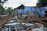 Warga membersihkan material bangunan sekolah yang ambruk akibat pergerakan tanah di Desa Girimukti, Singajaya, Kabupaten Garut, Jawa Barat, Senin (8/2/2021). Pergerakan tanah tersebut mengakibatkan sejumlah bangunan seperti ruang kelas, bangunan kantor desa, sarana olahraga desa, beberapa rumah warga retak dan ambruk. ANTARA JABAR/Candra Yanuarsyah/agr