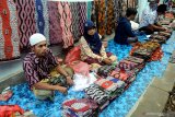 Pedagang menunggui batik dagangannya di Pasar Batik Tradisional, Pamekasan, Jawa Timur, Minggu (7/2/2021). Kebijakan Pemkab Pamekasan yang memberlakukan pakaian adat Madura, Baju Koko dan Batik Pamekasan, sebagai seragam Pegawai Negeri Sipil (PNS) dan non pegawai PNS disambut gembira oleh pelaku batik di daerah itu. Antara Jatim/Saiful Bahri/zk.