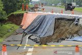 Pekerja memeriksa kondisi jalan tol yang ambles di ruas tol Cikopo-Palimanan (Cipali) KM 122, Kabupaten Subang, Jawa Barat, Rabu (10/2/2021). Kementerian Pekerjaan Umum dan Perumahan Rakyat (PUPR) dan Astra Tol Cipali akan melakukan percepatan penanganan amblesnya jalan di ruas tol Cipali KM 122 dengan membuat lajur sementara sepanjang 200 meter dengan waktu pengerjaan selama 10 hari. ANTARA JABAR/Dedhez Anggara/agr