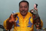 Dalang Sugiyo Waluyo memainkan sejumlah karakter Wayang Potehi secara virtual di rumahnya Perum Graha Kota, Suko, Sidoarjo, Jawa Timur, Senin (8/2/2021). Dalam rangka menyambut Tahun Baru Imlek, Dalang Sugiyo Waluyo melakukan latihan rekaman pertunjukan wayang potehi secara virtual yang diharapkan dapat tetap menghadirkan kemeriahan imlek meski harus dengan konsep yang berbeda. Antara Jatim/Umarul Faruq/zk