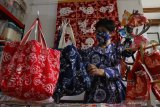 Desainer Lusiana Limono menata tas batik shio hasil karyanya yang dicetak dari origami atau seni melipat kertas di Studio Kait Handmade, Malang, Jawa Timur,  Kamis (11/2/2021). Berbagai produk turunan batik shio yang dibuat dengan cetakan origami tersebut dijual ke berbagai kota melalui pasar digital dengan harga Rp 25 ribu hingga 2,5 juta rupiah. Antara Jatim/Ari Bowo Sucipto/zk